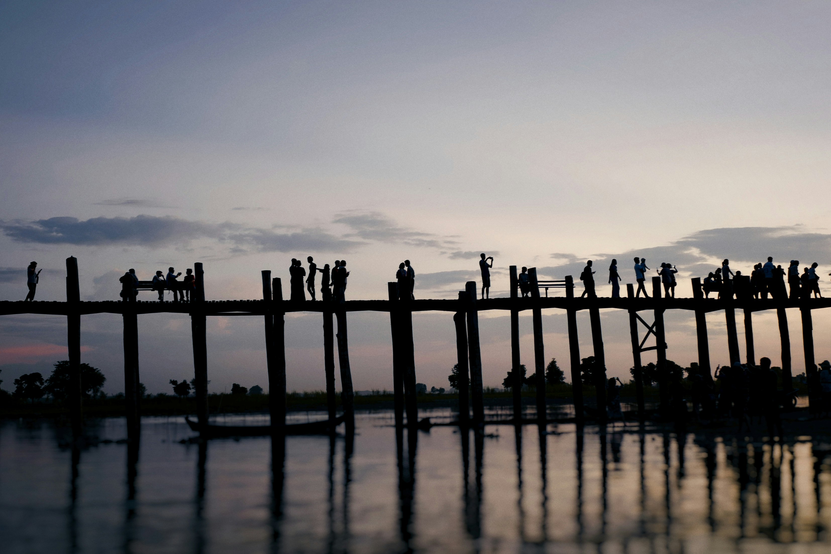 silhouette of people standing on dock during daytime